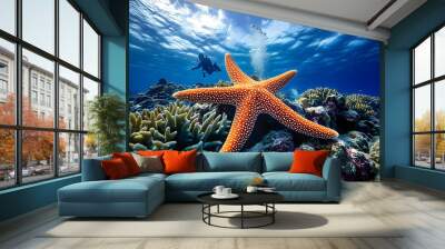 a starfish on a coral reef in the ocean with a blue background and a coral reef in the foreground with a diver in the background and a blue sky with a few clouds.  Wall mural